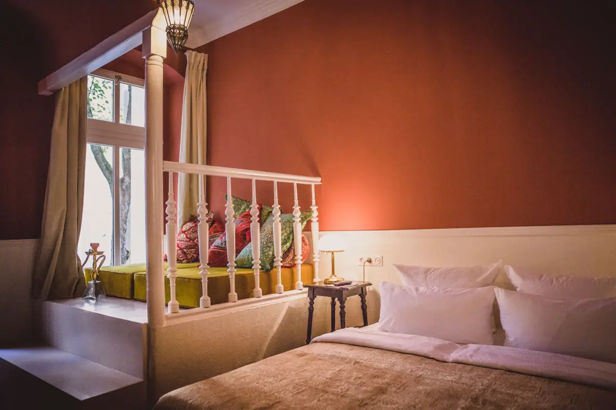 Bett mit Kissen und Lampe in einem Zimmer