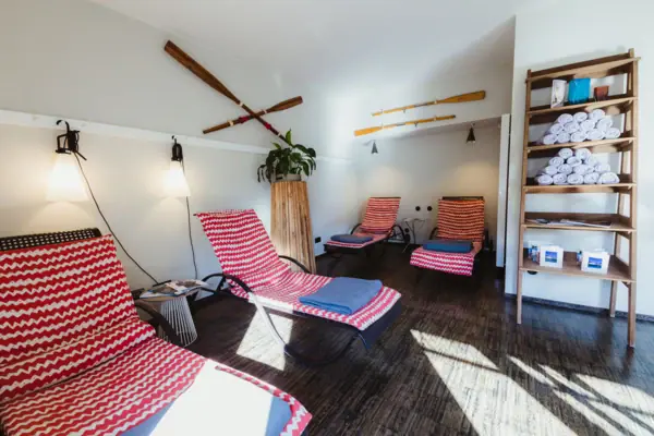 Liegen im Wellness-Bereich im HENRI Hamburg Ein Zimmer mit Stühlen und einem Regal.