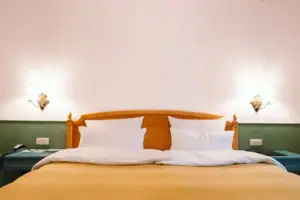 Ein Hotelzimmer im HENRI Hotel Garmisch-Partenkirchen mit einem Bett vor einer grün-weißen Wand.