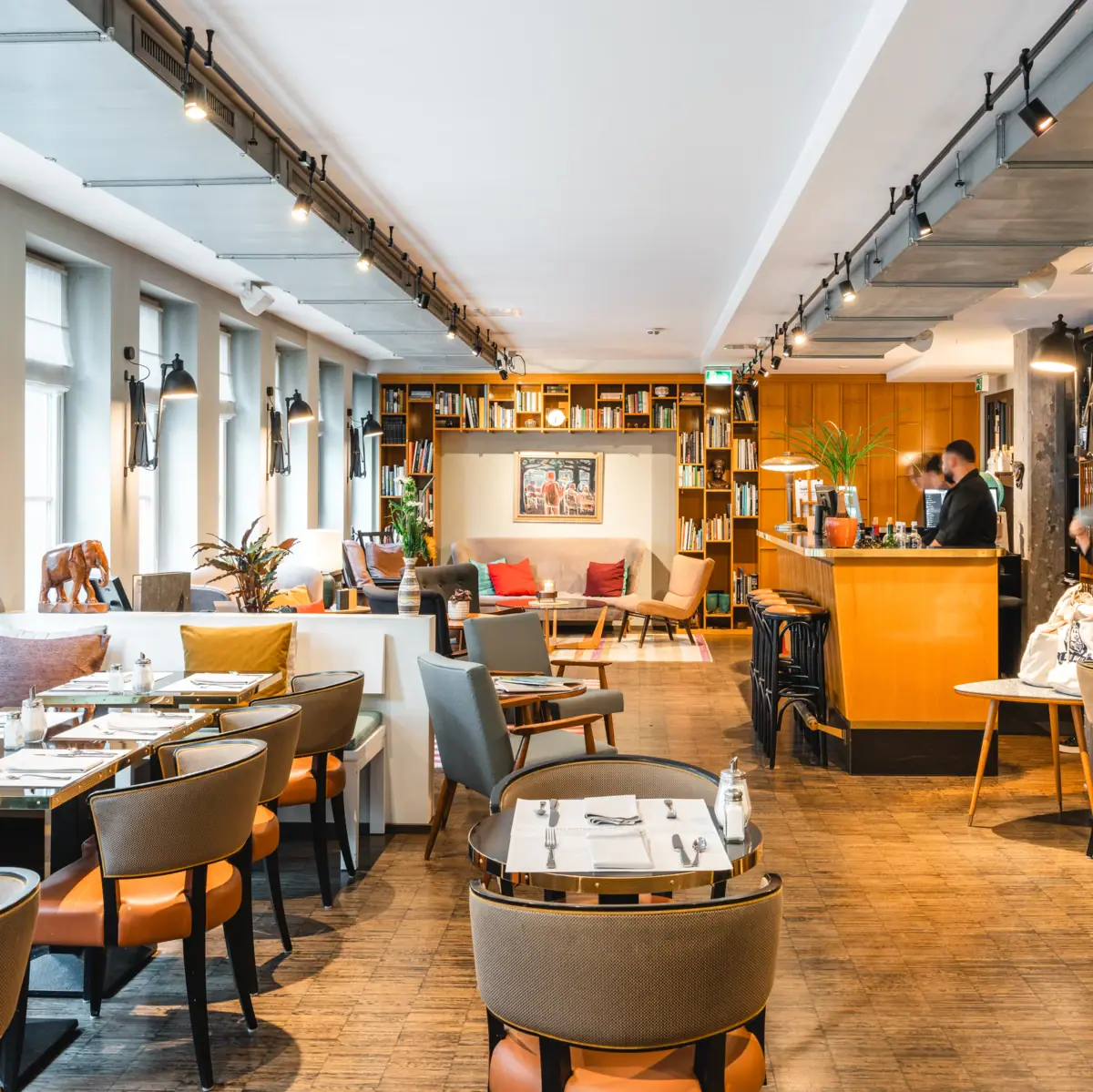 Einladender Loungebereich mit vielen Tischen, Stühlen und Bänken.