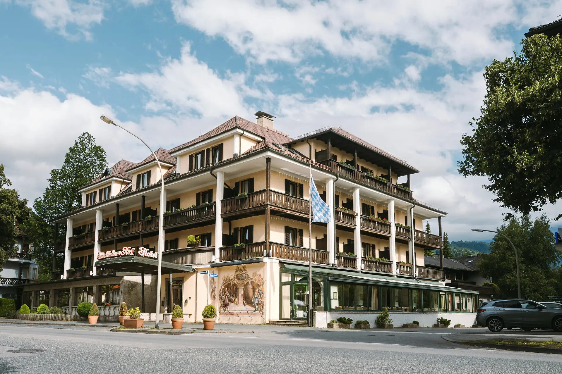 Außenansicht HENRI Hotel Garmisch-Partenkirchen Außenansicht HENRI Hotel Garmisch-Partenkirchen mit Bäumen und einer Straße.