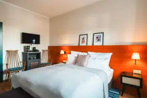 Bett mit weißer Decke und rotem Kopfteil