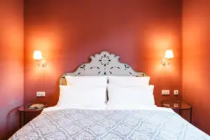 Ein Bett mit Kissen und einer Wandlampe.