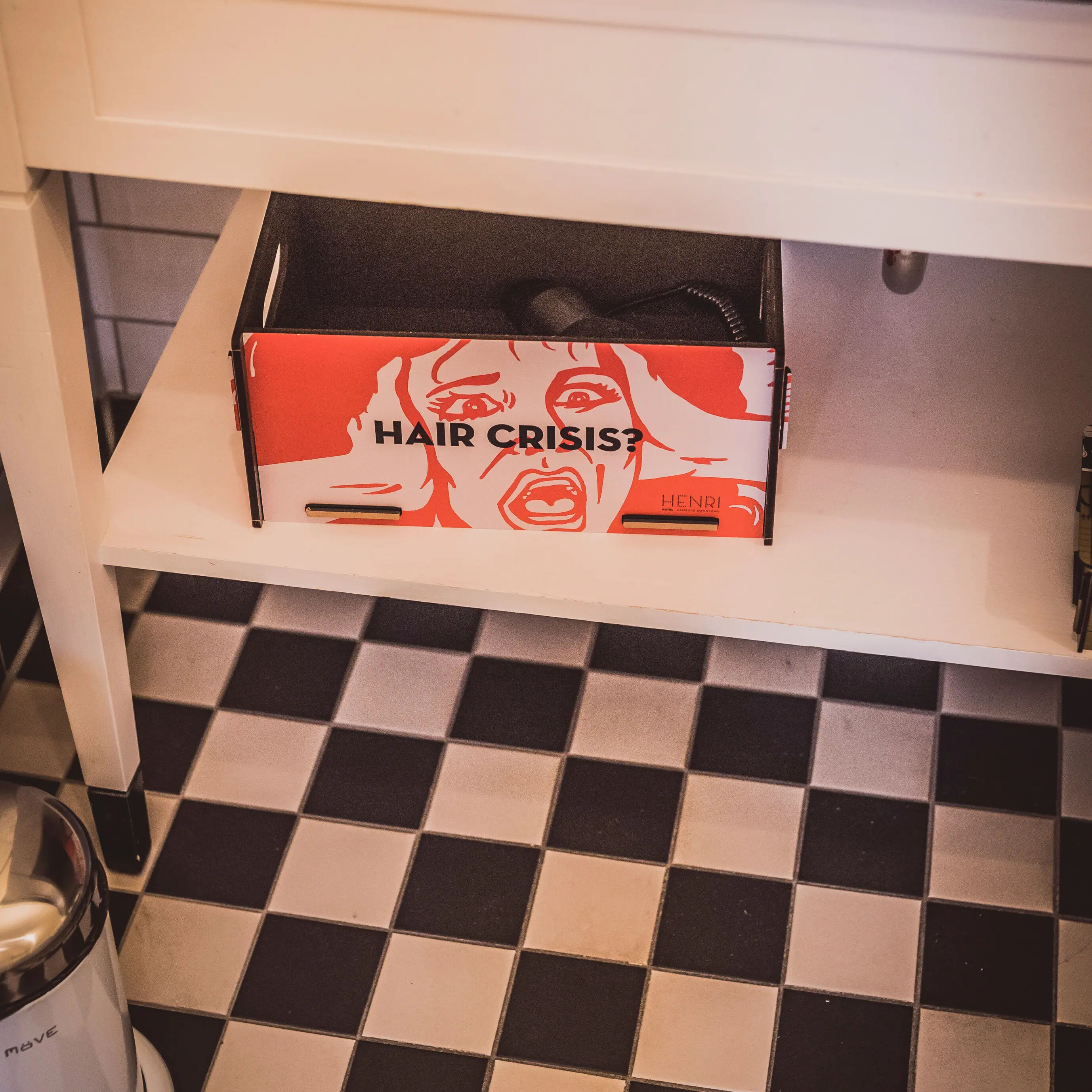 Bunte Kiste mit Föhn auf einem Badezimmerregal