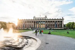 Die imposante Säulenfront des Alten Museums am Berliner Lustgarten bei tiefstehender Sonne mit Brunnen im Vordergrund
