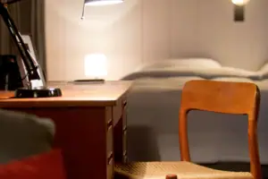 Ein Schreibtisch mit einer Lampe und einem Stuhl.