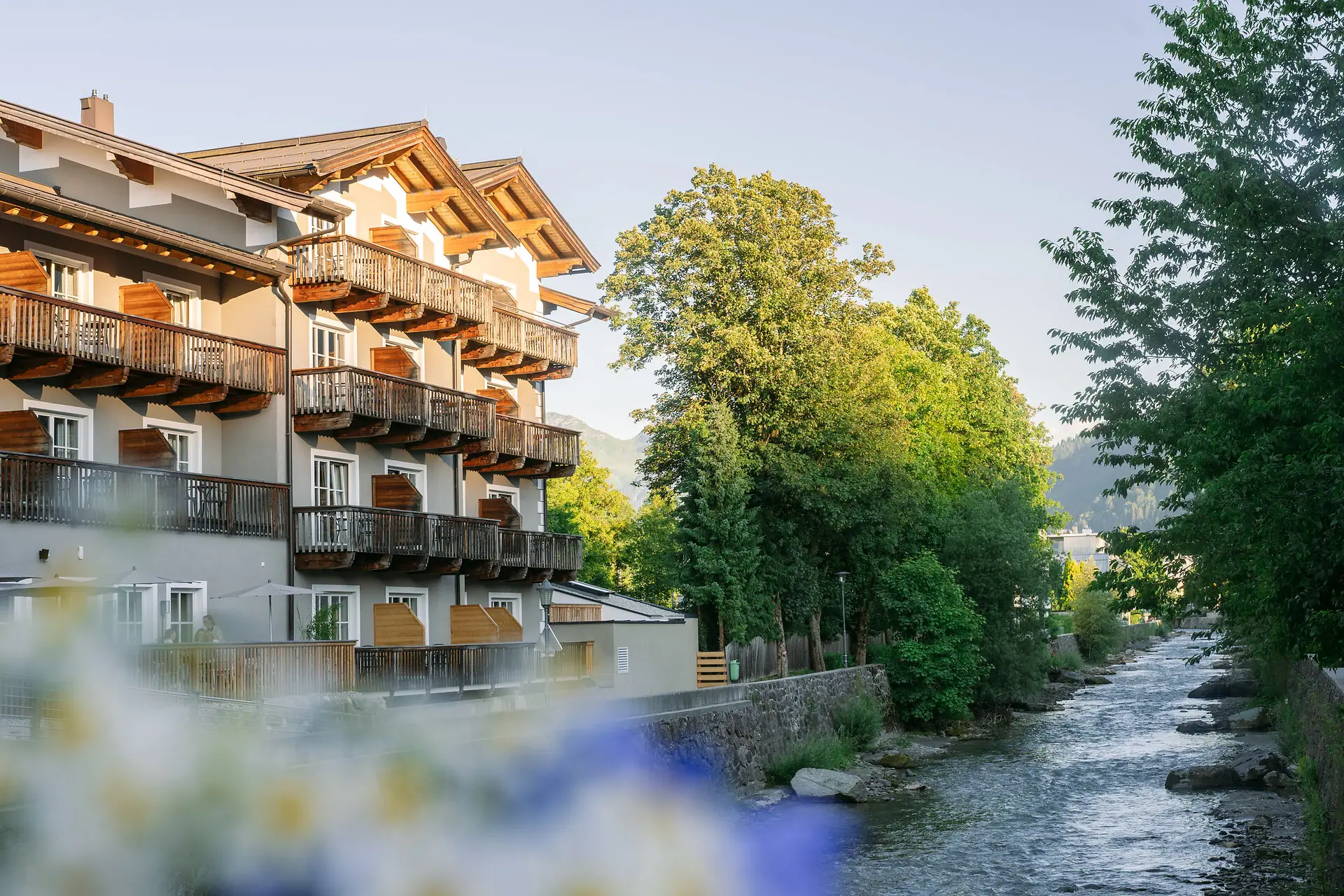 HENRI Kitzbühel Ein Gebäude neben einem Fluss.