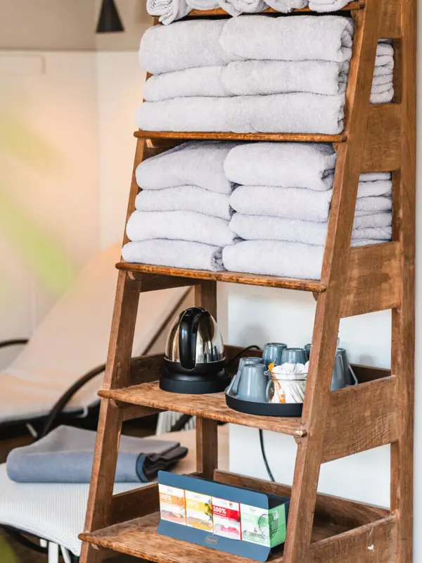 Ein Stapel Handtücher auf einem Holzregal.