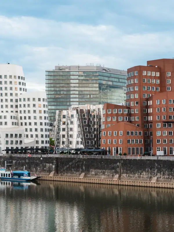Ein Fluss mit Booten und Gebäuden im Hintergrund.