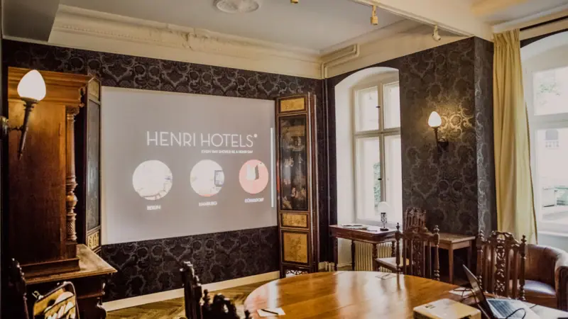 Ein Zimmer mit einer Projektionsleinwand und Holzmöbeln.