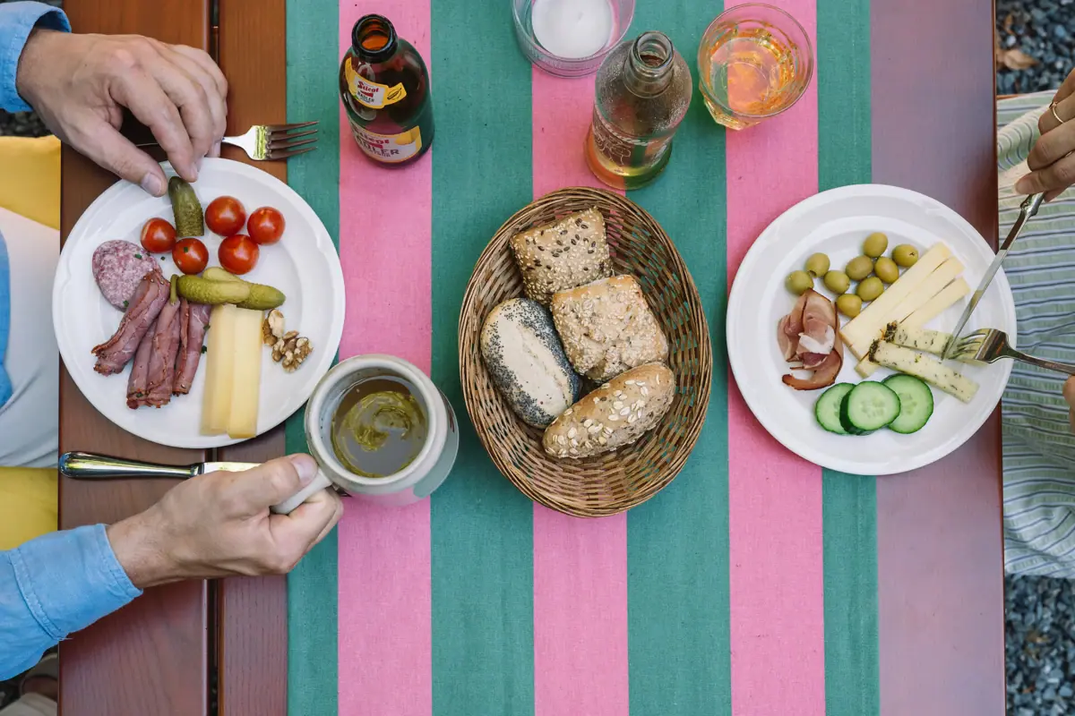 Person hält eine Tasse und einen Teller mit Essen.