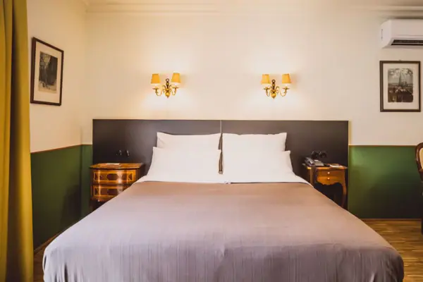 Zimmer Bett mit zwei Wandlampen in einem stilvollen Hotelzimmer.