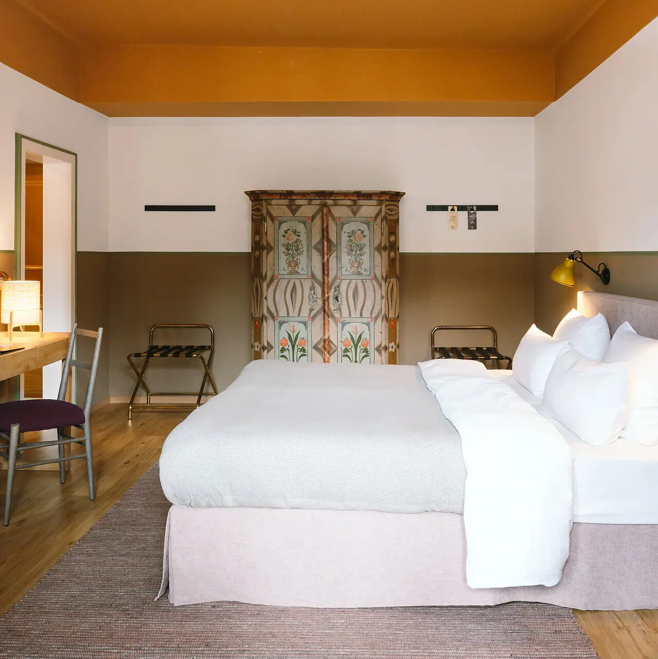 Hotelzimmer im HENRI Garmisch-Partenkirchen Ein Bett in einem Hotelzimmer mit stilvollem Interieurdesign.