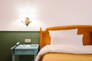 Das Hotelzimmer Chambre im HENRI Hotel Garmisch-Partenkirchen mit einem Bett vor einer grün-weißen Wand.