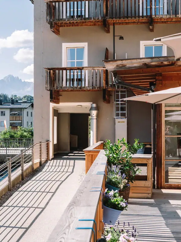 Ein Gebäude mit einer Terrasse und Sonnenschirmen.