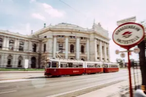 Ein rot-weißer Straßenbahnwagen auf einer Straße.
