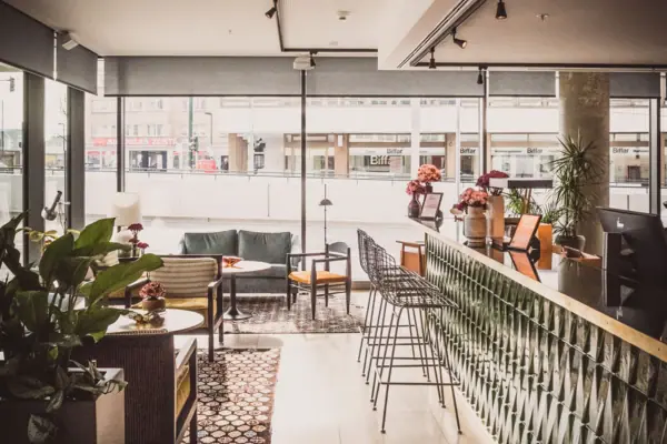 HENRI Düsseldorf Ein Raum mit einer Bar und Stühlen.