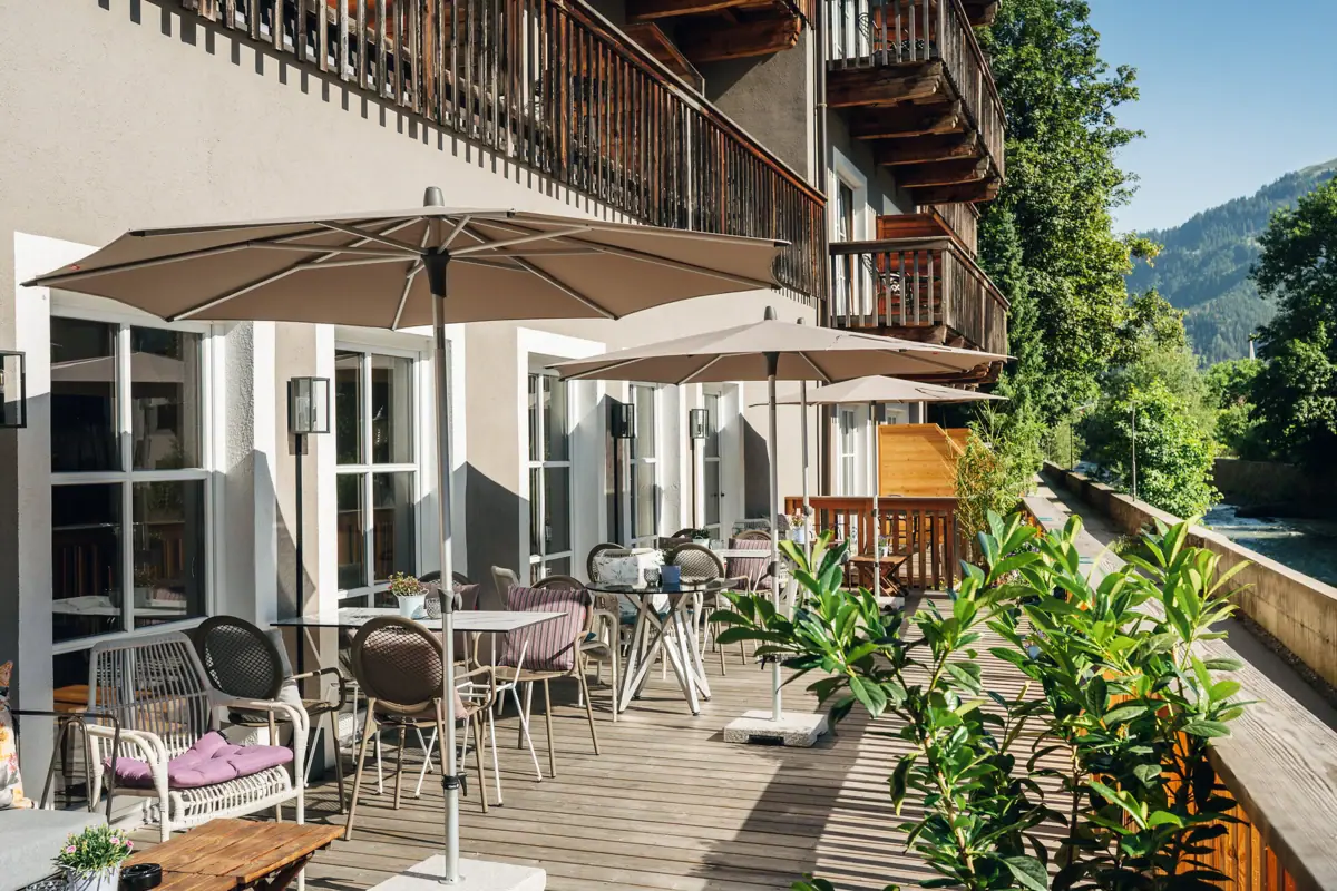 Eine Terrasse mit Stühlen und Sonnenschirmen auf einem Deck.