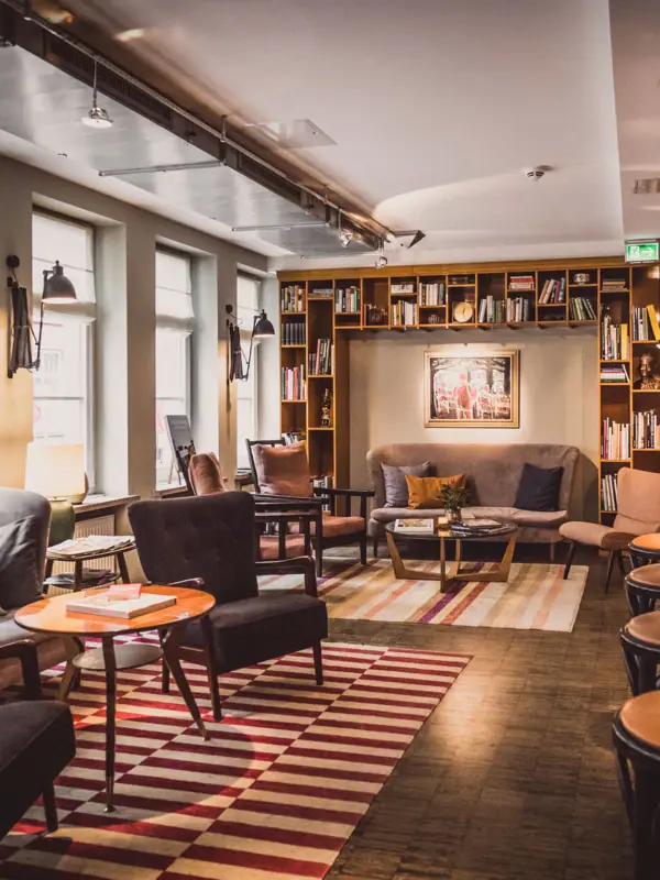 Sitzgruppen aus Sesseln, Tischen und einem Sofa im Loungebereich.