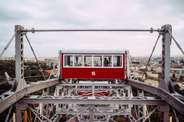 Prater Rotes und weißes Riesenrad vor bewölktem Himmel.