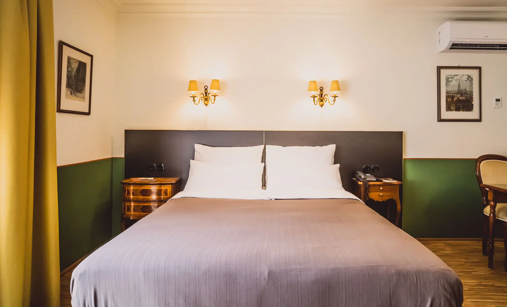 Bett mit zwei Wandlampen in einem stilvollen Hotelzimmer.